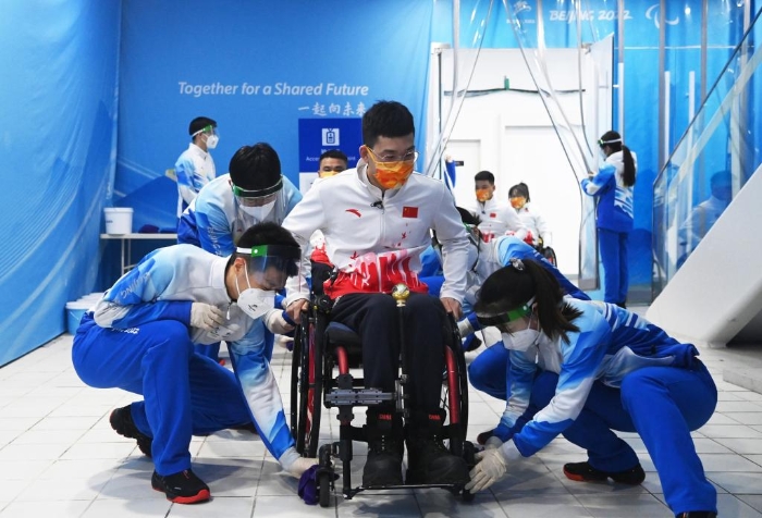 3月6日，志愿者赛前为中国队选手陈建新清洁轮椅。新华社记者任超摄